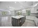 Bright kitchen featuring a center island with quartz countertop and modern appliances at 5018 Hanging Moss Ln, Sarasota, FL 34238