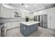 Modern kitchen with stainless steel appliances, gray island, and ample storage space at 5018 Hanging Moss Ln, Sarasota, FL 34238
