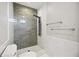 Modern shower with gray tile, rainfall showerhead, and marble accent wall at 5018 Hanging Moss Ln, Sarasota, FL 34238