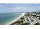 Expansive aerial view of a beach featuring turquoise ocean waters, white sands, and lush green vegetation at 510 Wedge Ln, Longboat Key, FL 34228