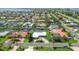 Aerial view of homes with canal access and boat docks, surrounded by lush landscaping and mature palm trees at 510 Wedge Ln, Longboat Key, FL 34228