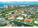 Aerial view of homes lining canals with pools, boat docks, palm trees, and beach condos in the distance at 510 Wedge Ln, Longboat Key, FL 34228