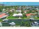 Aerial view of homes lining canals and boat docks, complemented by lush palm trees and manicured lawns at 510 Wedge Ln, Longboat Key, FL 34228