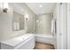 Bright bathroom features a modern vanity, mirror, and a glass-enclosed bathtub with shower at 510 Wedge Ln, Longboat Key, FL 34228