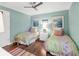 Bright bedroom with hardwood floors, ceiling fan, and twin beds with colorful bedding at 510 Wedge Ln, Longboat Key, FL 34228