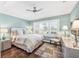 A well-lit bedroom features hardwood floors, a ceiling fan, and a bright window with shutters at 510 Wedge Ln, Longboat Key, FL 34228