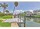 Dock with ladder on canal with lush landscaping and homes in the background on a sunny day at 510 Wedge Ln, Longboat Key, FL 34228