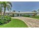 Beautiful home exterior features a brick driveway, lush landscaping, and well-manicured lawn at 510 Wedge Ln, Longboat Key, FL 34228