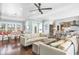 Bright, open-concept living room featuring hardwood floors, ceiling fan, and views into the kitchen at 510 Wedge Ln, Longboat Key, FL 34228
