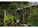 Whimsical outdoor area featuring a Fish Camp sign, lush greenery, and various decorative elements for a rustic feel at 510 Wedge Ln, Longboat Key, FL 34228