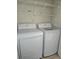 Well-equipped laundry area with a modern washer, dryer, and shelving for organized storage at 5146 Northridge Rd # 310, Sarasota, FL 34238
