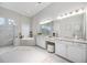 Bright bathroom featuring a soaking tub, glass shower, granite counters, and dual sink vanity with ample storage at 5328 Brookgrove Dr, Sarasota, FL 34238