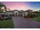 Luxury home showing landscaping and a paver driveway as well as a grass lawn at 5328 Brookgrove Dr, Sarasota, FL 34238