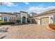 Beautiful home exterior showcasing a three-car garage, and lush landscaping with a paver driveway at 5328 Brookgrove Dr, Sarasota, FL 34238