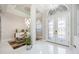 Bright foyer featuring tile flooring, modern light fixtures, and a view into the dining room at 5328 Brookgrove Dr, Sarasota, FL 34238
