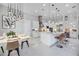 Bright modern kitchen with white cabinets, stainless steel appliances, large island, and adjacent dining area under elegant pendant lights at 5328 Brookgrove Dr, Sarasota, FL 34238