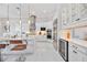 A bright, modern kitchen features white cabinetry, stainless steel appliances including a wine fridge, and a marble-topped island at 5328 Brookgrove Dr, Sarasota, FL 34238
