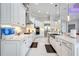 Spacious kitchen featuring white cabinets, stainless steel appliances, and a large island with marble countertops and modern lighting at 5328 Brookgrove Dr, Sarasota, FL 34238
