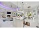 Modern kitchen with white island, stainless steel appliances, and view of living room with fireplace and access to outdoor pool area at 5328 Brookgrove Dr, Sarasota, FL 34238