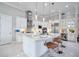 A modern kitchen featuring white cabinets, stainless appliances, and a large island with bar stools for seating and food prep at 5328 Brookgrove Dr, Sarasota, FL 34238