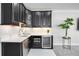 Charming kitchenette featuring sleek black cabinetry, stainless steel appliances, and elegant countertops at 5328 Brookgrove Dr, Sarasota, FL 34238