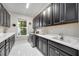 Well-equipped laundry room with black cabinets, white countertops, stainless steel washer and dryer, and tile flooring at 5328 Brookgrove Dr, Sarasota, FL 34238