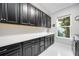 Well-lit laundry room boasts modern cabinets, white counters, and a large window at 5328 Brookgrove Dr, Sarasota, FL 34238
