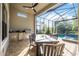 Outdoor covered patio with dining area, built-in grill, and ceiling fan overlooking the pool area at 5328 Brookgrove Dr, Sarasota, FL 34238