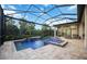 Backyard pool and lanai with lush greenery and elegant lighting perfect for evening swims at 5328 Brookgrove Dr, Sarasota, FL 34238