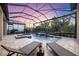 Sunset view of the backyard pool and lanai. Perfect for relaxing evenings with a luxurious, private feel at 5328 Brookgrove Dr, Sarasota, FL 34238