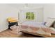 A bedroom showcasing a modern desk, wood-look flooring, and bright natural light from the window at 5500 Longwood Run Blvd # 203, Sarasota, FL 34243