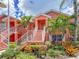 Charming coral condo showcasing vibrant landscaping and a welcoming staircase entrance at 5500 Longwood Run Blvd # 203, Sarasota, FL 34243