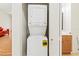 Laundry area with a stacked washer and dryer, and adjacent bathroom with a modern vanity at 5500 Longwood Run Blvd # 203, Sarasota, FL 34243
