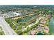 Expansive aerial view of a residential community featuring a lake with fountain, lush landscaping, and nearby retail at 5728 Ashton Lake Dr # 12, Sarasota, FL 34231