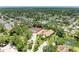 Aerial view of home featuring tennis courts, lush greenery, a pond, and circular driveway at 5728 Ashton Lake Dr # 12, Sarasota, FL 34231