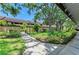 Exterior walkway lined with lush greenery, leading to residential buildings at 5728 Ashton Lake Dr # 12, Sarasota, FL 34231