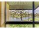 Framed view of a tranquil lake featuring a fountain, seen through a screened lanai at 5728 Ashton Lake Dr # 12, Sarasota, FL 34231