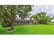 Lush backyard with a screened lanai, mature trees, and well-maintained lawn at 6107 Misty Oaks St, Sarasota, FL 34243