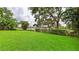 Expansive backyard featuring a manicured lawn and privacy hedges at 6107 Misty Oaks St, Sarasota, FL 34243
