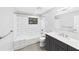 Bathroom featuring a double sink vanity, new toilet, tiled shower, and window at 6107 Misty Oaks St, Sarasota, FL 34243