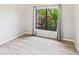 Cozy bedroom with neutral walls, hardwood floors, and black-framed window letting in natural light at 6107 Misty Oaks St, Sarasota, FL 34243