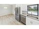 Modern kitchen with stainless steel refrigerator and a view of the pool area from the sink at 6107 Misty Oaks St, Sarasota, FL 34243