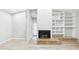 Open living space with a brick fireplace, built-in shelving, and neutral walls at 6107 Misty Oaks St, Sarasota, FL 34243
