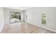 Living room with ceiling fan, neutral walls, hardwood flooring, and sliding doors leading to outdoor pool at 6107 Misty Oaks St, Sarasota, FL 34243
