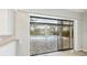 View of the screened-in pool area from inside the home through large sliding glass doors at 6107 Misty Oaks St, Sarasota, FL 34243