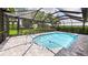 A beautiful screened-in pool features tiled brick patio, mature landscaping, and clear blue water at 6107 Misty Oaks St, Sarasota, FL 34243