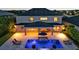 Aerial view of backyard pool, covered patio, lounge chairs and fire pits in the evening light at 6302 Anise Dr, Sarasota, FL 34238