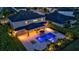 Aerial view of backyard pool with a hot tub, lounge chairs, and a covered patio at dusk at 6302 Anise Dr, Sarasota, FL 34238