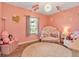 Bright Bedroom painted pink features a comfortable crib and decorative accents at 6302 Anise Dr, Sarasota, FL 34238