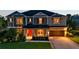 Two-story home exterior with well-manicured lawn, inviting porch, and warm lighting at 6302 Anise Dr, Sarasota, FL 34238
